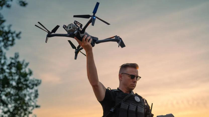 A law enforcement officer holds a Skydio X10 in their outstretched hand, preparing to launch the drone. 